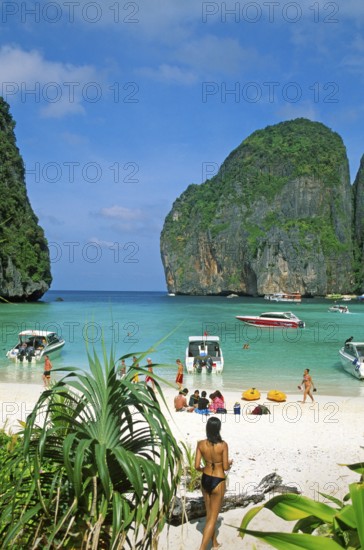 Palm tree, people, longtail boats on Maya Bay beach, known from the movie The Beach, one year in front of the tsunami, Ko Phi Phi Le, Thailand, December 2002, vintage, retro, old, historic