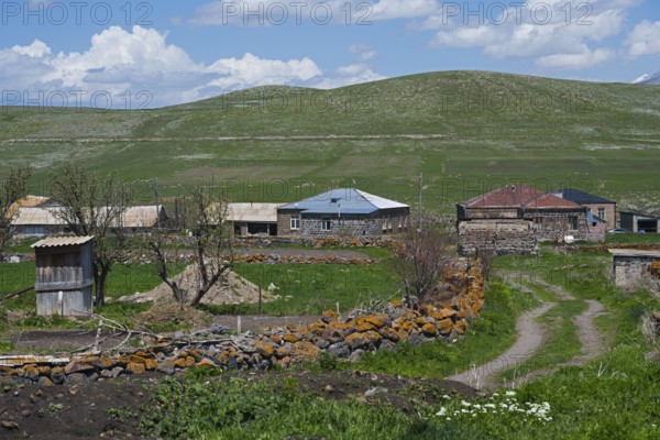Quiet rural village with stone houses and green fields under blue sky, Jigrasheni, Samtskhe—Javakheti region, Samtske Javacheti, Lesser Caucasus, Georgia