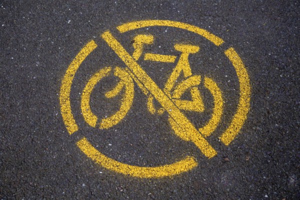 Yellow no cycling sign spray painted on tarmac path surface, Horniman, Museum, Forest Hill, London, England, UK