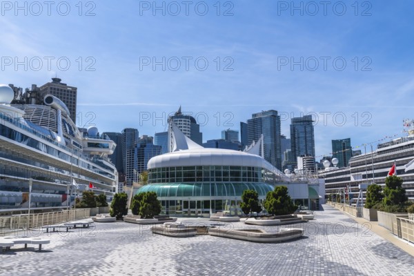 Canada place, a prominent landmark and cruise ship terminal in vancouver, british columbia, stands tall against a backdrop of modern skyscrapers, welcoming tourists on a sunny day