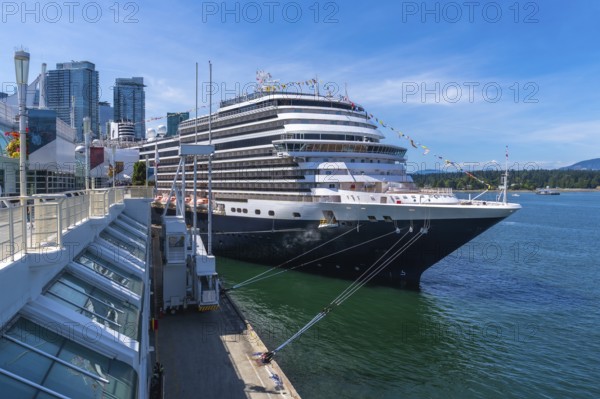 Large cruise ship docking at canada place cruise terminal in vancouver, british columbia, with city skyline and harbor in background on a sunny day