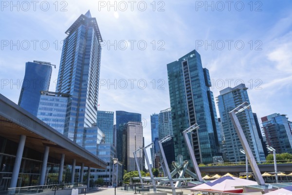 Glass skyscrapers and modern architecture dominate the skyline of vancouver, british columbia, on a bright sunny day, showcasing the city's vibrant urban landscape