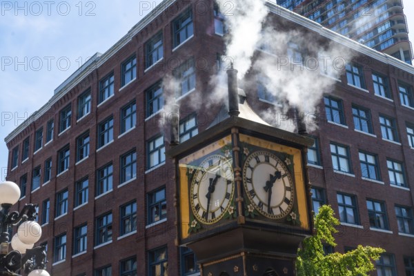 Steam clock releasing vapor against a backdrop of a red brick building and a bright blue sky, capturing the essence of gastown in vancouver, british columbia