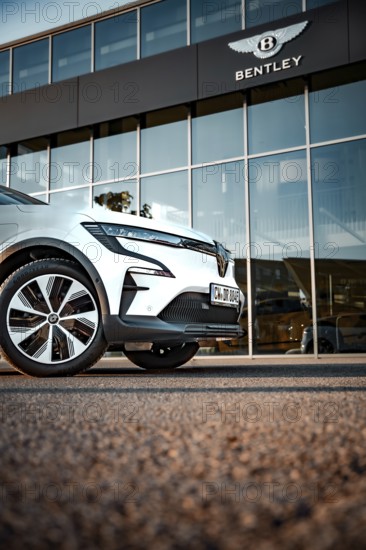 Car in front of a Bentley logo building, modern design and glass façade, Deer e-car sharing, Renault Megane, Calw, Germany
