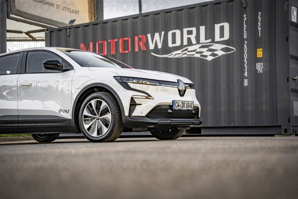 White electric car in front of a black container with Motorworld logo, Deer e-Carsharing, Renault Megane, Calw, Germany