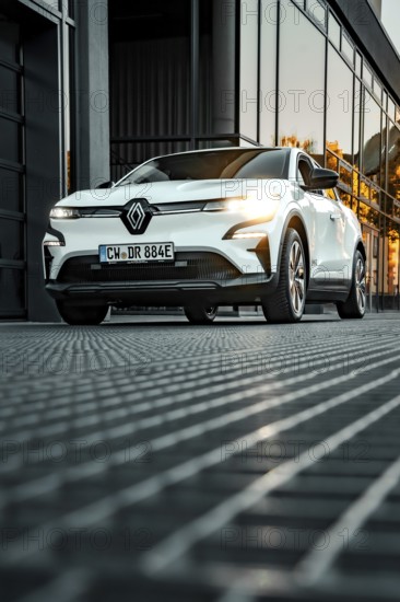 Renault car in front of reflecting windows at sunset in urban environment, Deer e-car sharing, Renault Megane, Calw, Germany