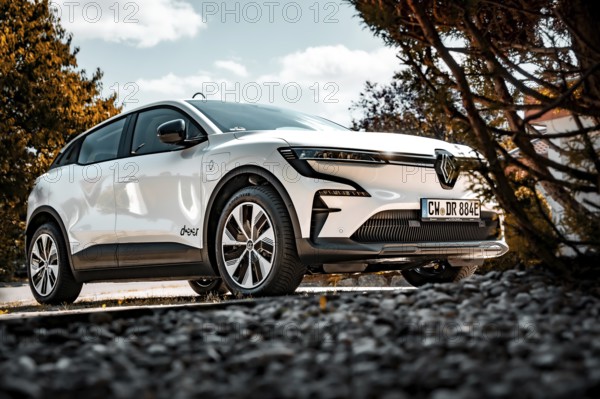 White electric car on a stone path, surrounded by trees, in sunshine, Deer e-Carsharing, Renault Megane, Calw, Germany