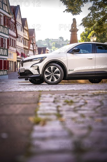 White car on cobblestone road surrounded by half-timbered houses and trees, Deer E-Carsharing, Renault Megane, Calw, Germany