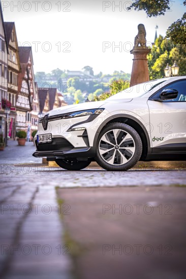 Profile view of a white car in a picturesque historic town in sunshine, Deer e-car sharing, Renault Megane, Calw, Germany