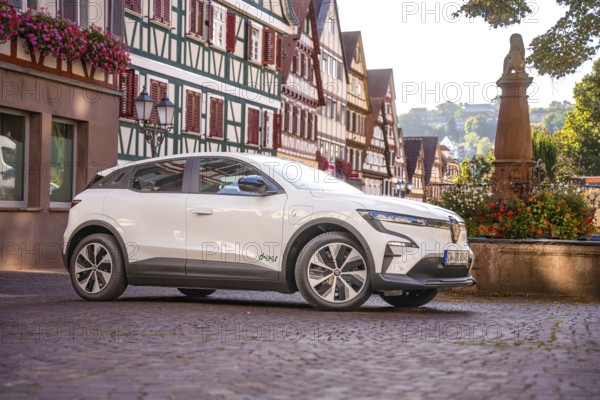 Side view of white car in a historic town with half-timbered houses in summer, Deer e-car sharing, Renault Megane, Calw, Germany