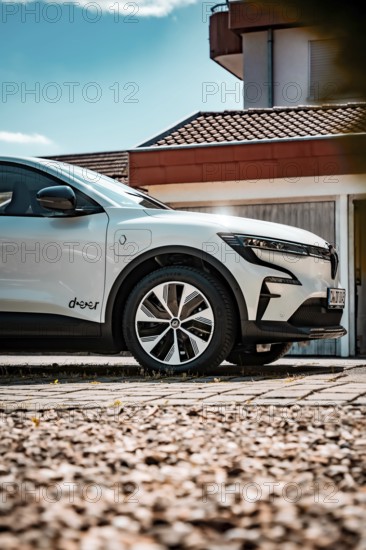 White electric car standing on paved ground in front of a modern house, Deer e-Carsharing, Renault Megane, Calw, Germany