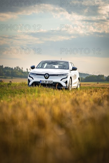 A white car is parked in a field under a wide, clear sky, Deer E-Carsharing, Renault Megane, Calw, Germany