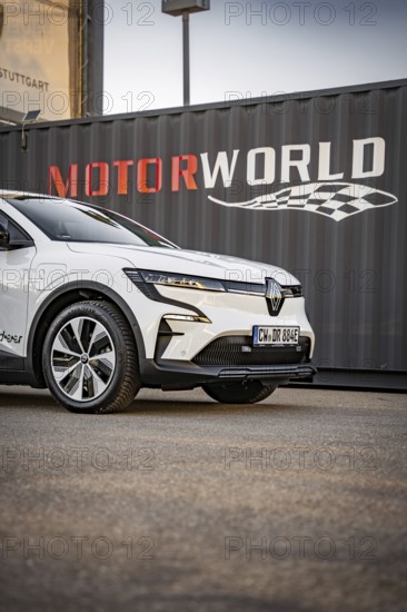 Close-up of a white electric car in front of a container with Motorworld logo, Deer E-Carsharing, Renault Megane, Calw, Germany