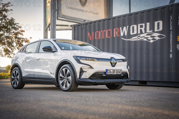 A white electric car stands in front of a Motorworld container with good lighting, Deer e-Carsharing, Renault Megane, Calw, Germany