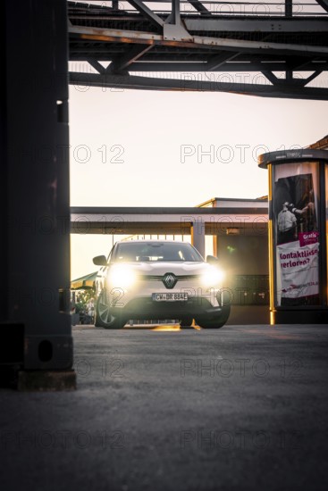 Car in evening lighting on an urban sidewalk surrounded by lanterns, Deer E-Carsharing, Renault Megane, Calw, Germany