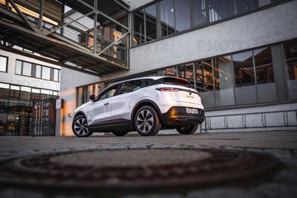 Modern car in front of an urban building in the evening mood with lots of reflections, Deer E-Carsharing, Renault Megane, Calw, Germany