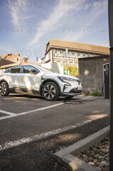 Car at a charging station in front of a half-timbered house in a sunny parking lot, Deer E-Carsharing, Renault Megane, Calw, Germany