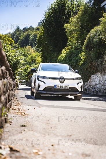 Car on a sunny road surrounded by green nature and forest, Deer e-Carsharing, Renault Megane, Calw, Germany