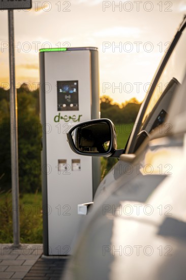 A vehicle is parked at a charging station in a rural area at sunset, Deer E-Carsharing, Renault Megane, Calw, Germany