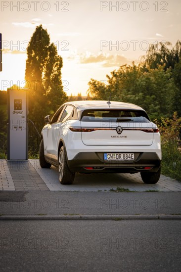 A car charges at a station, illuminated by the warm shade of sunset, Deer E-Carsharing, Renault Megane, Calw, Germany