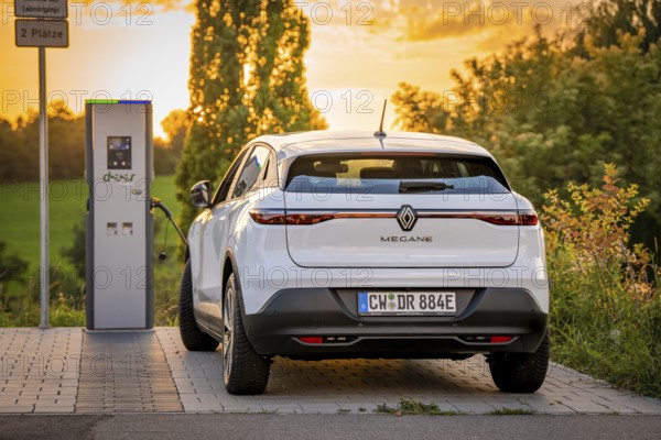 An electric car parks peacefully at a charging station in the evening light, Deer E-Carsharing, Renault Megane, Calw, Germany