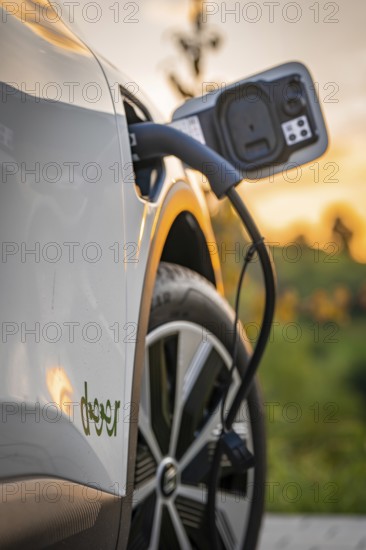 Electric car is charged at a charging station during autumn sunset, Deer e-Carsharing, Renault Megane, Calw, Germany