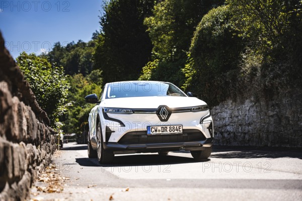 White car driving down a tree-lined stone road, Deer E-Carsharing, Renault Megane, Calw, Germany