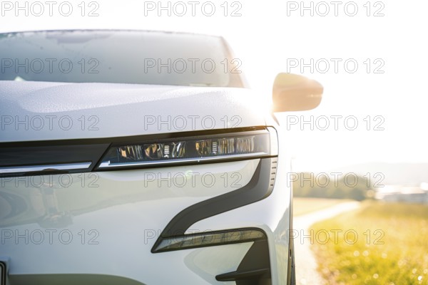 Front part of a white car with modern headlights in sunny surroundings, Deer E-Carsharing, Renault Megane, Calw, Germany