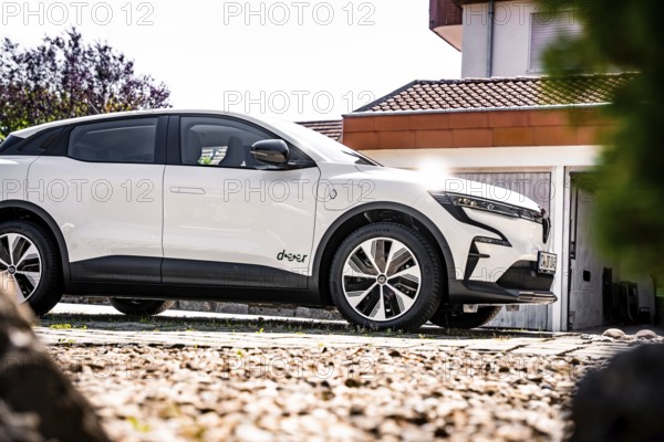White modern car on a rocky courtyard with house in the background, Deer e-Carsharing, Renault Megane, Calw, Germany