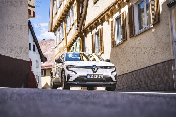 Renault on a sunny road between buildings with traditional architecture, Deer e- car sharing, Renault Megane, Calw, Germany