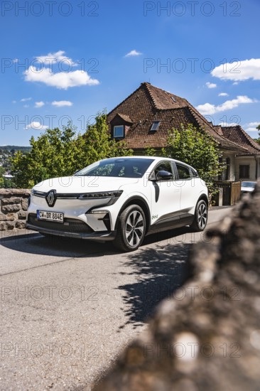 White car on a village road under blue sky in sunshine, Deer E-Carsharing, Renault Megane, Calw, Germany