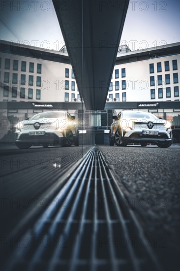 Car reflecting a modern building in an urban environment at dusk, Deer E-Carsharing, Renault Megane, Calw, Germany