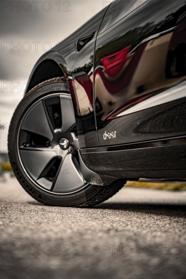 Close-up of a shiny black car with focus on tires, Deer E-Carsharing, Tesla Model 3, Calw, Germany