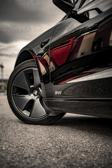 Close-up of a car tire on asphalt, reflective surface, Deer e-car sharing, Tesla Model 3, Calw, Germany
