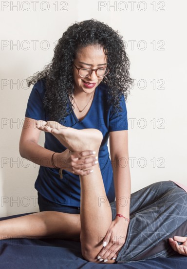 Physiotherapist with patient performing knee flexion, Physiotherapist performing knee flexion physiotherapy, knee rehabilitation concept