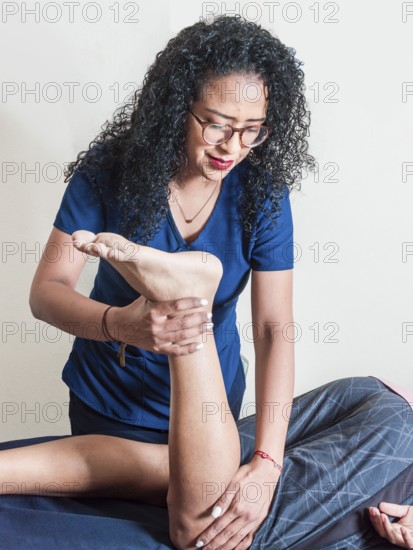 Physiotherapist performing knee flexion physiotherapy, Physiotherapist with patient performing knee flexion, knee rehabilitation concept