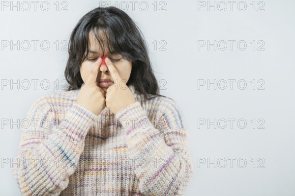 Asian woman with rhinitis touching nose. Close up of young woman with sinus pain touching nose isolated