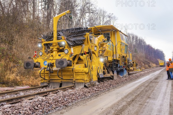 Large track construction machines with workers at the railway construction site in the forest, tamping machine on Hermann, Hesse, railway, Althengstett, Calw district, Germany