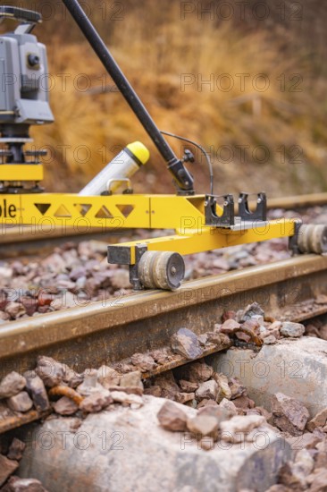 Close-up of a yellow device on railroad tracks in an autumn landscape, stuffing machine on Hermann, Hesse, railroad, Althengstett, Calw district, Germany
