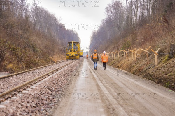 Construction worker and machine tool working on a railroad track in the forest, tamping machine on Hermann, Hesse, Bahn, Althengstett, Calw district, Germany