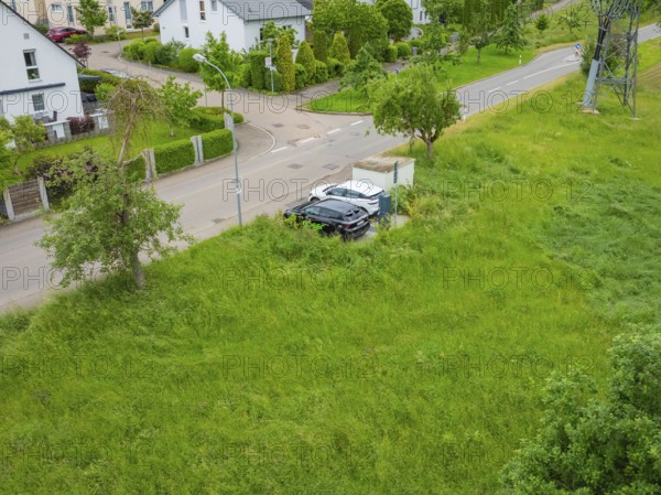 Drone image of a residential area with houses, street and lots of vegetation, deer e-car sharing, Calw, Germany