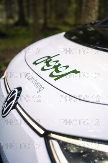 Close-up view of the hood of a car with car sharing logo in the forest, Deer E- Carsharing, VW ID3, Calw, Germany