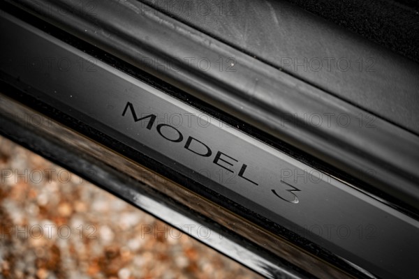 Close-up of a black car with model 3 emblem on a metallic surface, Deer E- car sharing, Tesla Model 3, Calw, Germany