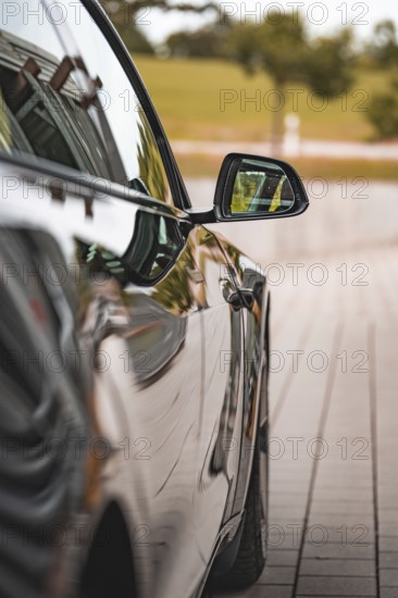 Close-up view of a black car with side mirror on a road, Deer e-Carsharing, Tesla Model 3, Calw, Germany
