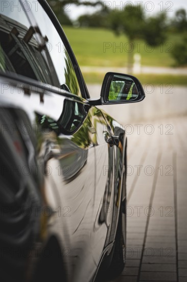 Side view of black car with reflecting side mirror, Deer E- car sharing, Tesla Model 3, Calw, Germany