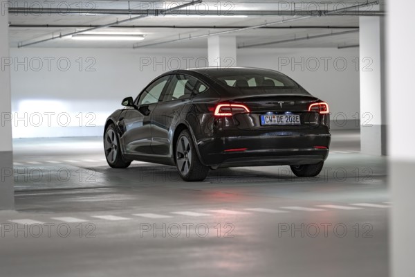Tesla car in parking garage, illuminated by white lamps, black body, Deer E-Carsharing, Tesla Model 3, Calw, Germany