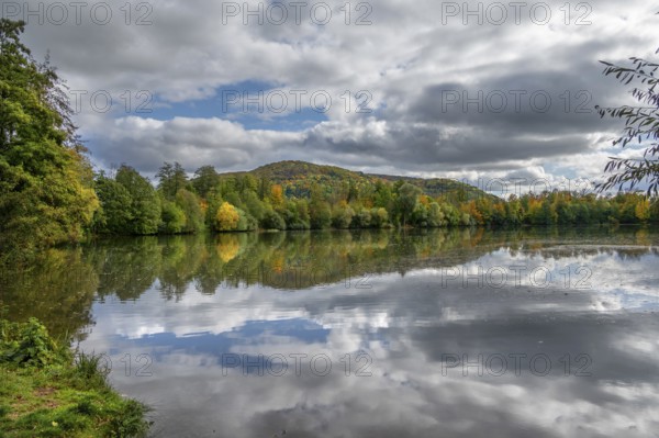 Mixed autumn forest reflected in Happurger Stausee, Happurg, Middle Franconia, Bavaria, Germany