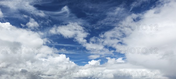 A peaceful sky filled with soft clouds creates a calming atmosphere under the bright sun of a clear daytime