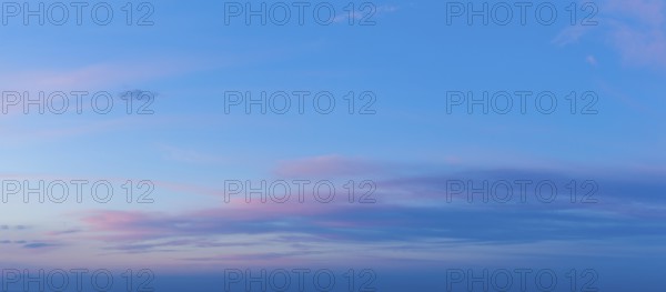 A beautiful twilight sky showcases vivid pink and blue colors as the sun sets, creating a serene and dramatic atmosphere in the evening