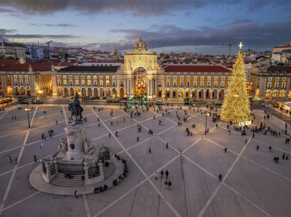 Praca do Comercio glows in the evening with a decorated Christmas tree and festive lights, creating a magical winter atmosphere. Lisbon, Portugal